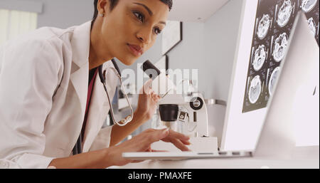 Giovane femmina intelligente radiologo cercando in un microscopio Foto Stock