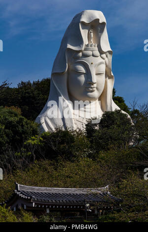 In alto al di sopra della linea di albero del monte Mugaso la statua di Kannon, la dea buddista della misericordia, sorge presso il gateway di Kamakura. Costruzione del Foto Stock