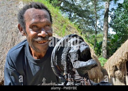 Un uomo della tribù Dani mostra la mummia sacra di una grande antenato. La mummia del leggendario guerriero della tribù, nei pressi di Wamena in città Il Baliem Valley. Foto Stock