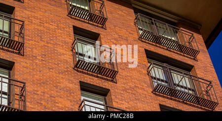 Il balcone di ogni camera di un edificio di mattoni rossi Foto Stock