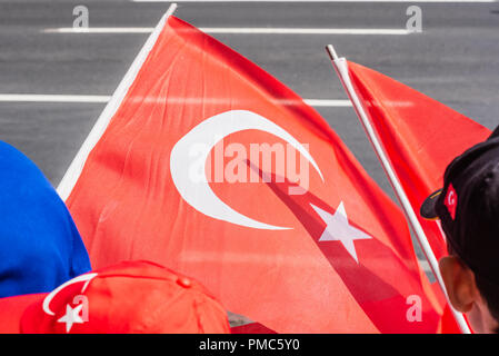 Con bandiera turca in primo piano,la gente guarda la parata militare a bagno turco 30 Agosto la Giornata della Vittoria a Istanbul, Turchia. Foto Stock