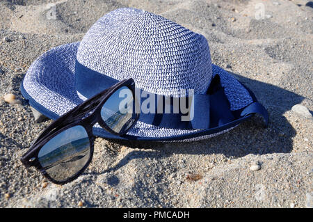 Occhiali da sole e un cappello sulla spiaggia Foto Stock