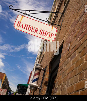 Un bianco e rosso Barber shop segno ha la ruggine al di sopra del polo a righe Foto Stock