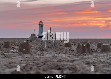 Il Sandcastles On la spiaggia, con serata nuvole e punto di Ayr il faro in background, vicino Talacre, Flintshire, Wales, Regno Unito Foto Stock