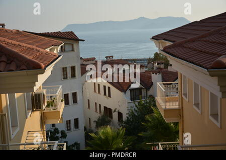 ANTALYA, TURCHIA - Agosto 31, 2018: la vista di Kaş Marina e la penisola di Cukurbag attraverso gli edifici da una collina Foto Stock
