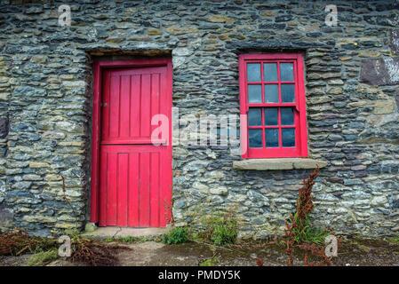 Un vintage porta e finestra su una facciata di un antico casolare in pietra in Irlanda Foto Stock