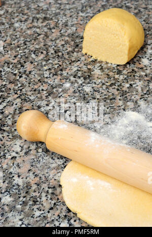 Pasta con un matterello e pronto per la preparazione di dolci e pasta sfoglia a casa, Sfondo marmo, verticale Foto Stock