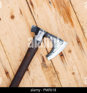 Viking Ax giace su di un tavolo di legno, vista dall'alto Foto Stock