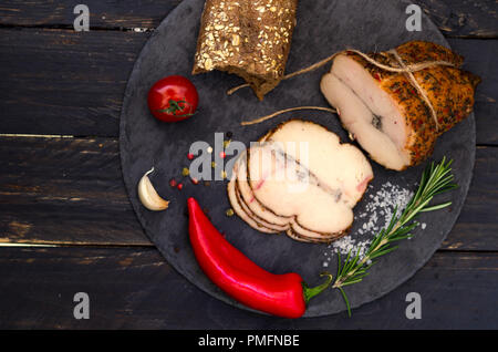 La carne con il peperoncino e i pomodori ciliegia. Il pane fatto in casa e le spezie. Vista dall'alto. Foto Stock