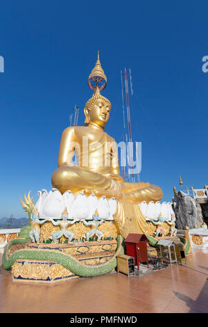Wat Tham Seua o Tiger tempio nella grotta mountain top golden statua del Buddha, Krabi, Thailandia Foto Stock