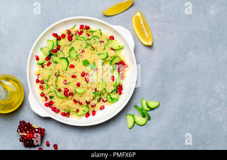 Il cous cous insalata con melograno, menta e cetrioli, sano cibo fatto in casa, pasto vegano Foto Stock