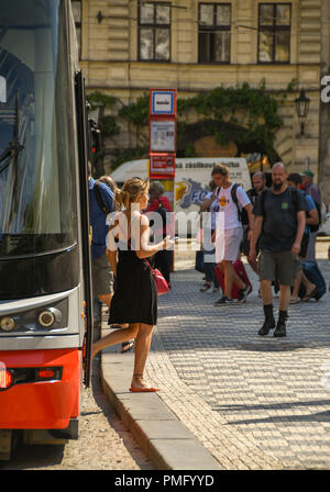 Signora giovane scendere un tram nel centro di Praga Foto Stock