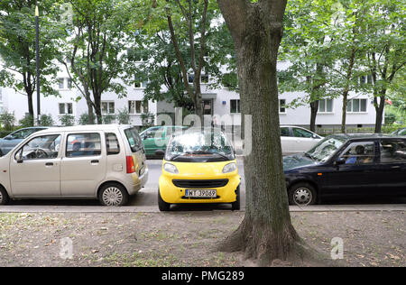 Varsavia Polonia un giallo Smart auto parcheggiate lateralmente in un piccolo spazio tra due vetture Foto Stock