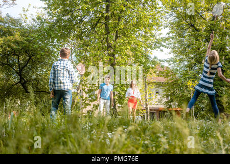 Famiglia giocando badminton su un prato in estate Foto Stock