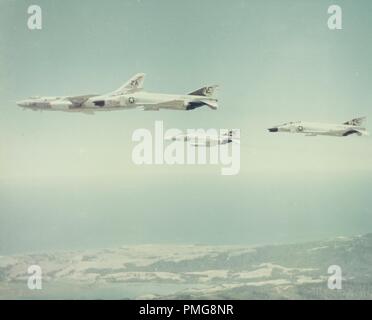 In bianco e nero la fotografia aerea mostra 4 marina degli Stati Uniti, McDonnell Douglas F-4 Phantom II di aerei in volo, con vista oceano e un paesaggio costiero della distanza, fotografato durante la Guerra del Vietnam, 1965. () Foto Stock