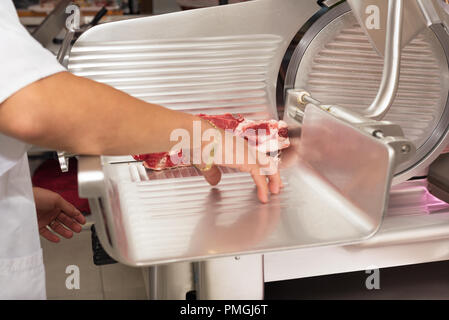 Butcher il taglio di carne in macelleria. Close up Foto Stock