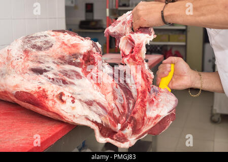 Butcher il taglio di carne in macelleria. Close up Foto Stock