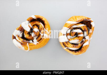 Vista dall'alto di due calde, pane appena sfornato, panini alla cannella su una placca da forno. Foto Stock