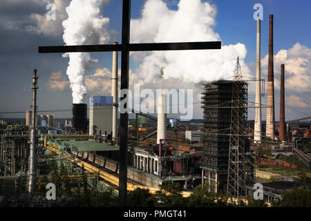 Vista dal Monte Alsumer in Duisburg sul Huettenwerk e altoforno Schwelgern I con Kokarei e impianti chimici su una enorme area di Thyssen Krupp am Rhein. La croce è stata eretta sul cumulo di macerie in memoria del quartiere Alsum, che era stato distrutto e non ricostruita nella seconda guerra mondiale. Foto Stock