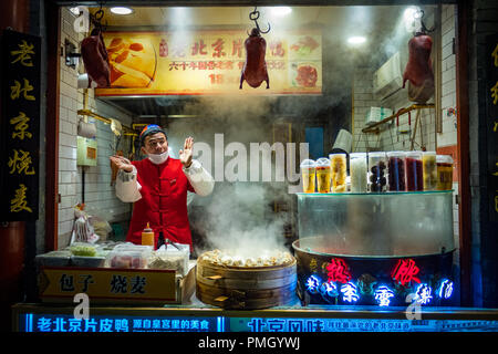 Pechino, Cina - Dic 20, 2017: fornitore cinese di Wangfujing street market alimentare la vendita di anatra di Pechino e Baozi di notte Foto Stock