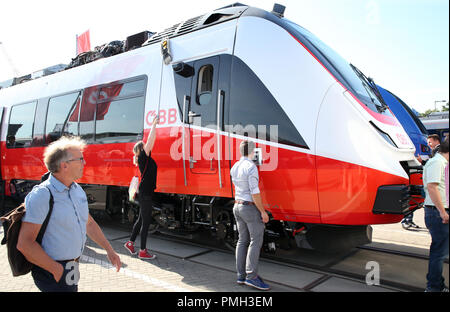 18 settembre 2018, Berlin: una fiera commerciale dipendente è la pulizia di un Bombardier treno delle ferrovie federali austriache a Innotrans fiera ferroviaria, mentre i visitatori a piedi attraverso la zona espositiva tra il sale sotto la torre della radio. Foto: Wolfgang Kumm/dpa Foto Stock