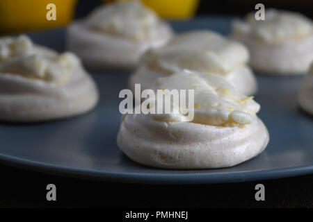 Vegano bit di meringa al limone cagliata su una piastra di colore blu Foto Stock