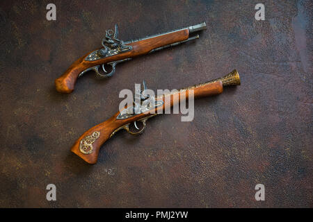 Due pistole vintage su sfondo di legno, tonica Foto Stock