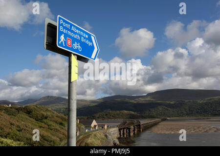 Cartello con la punta rivolta verso il basso verso Barmouth's pedonale e ponte ferroviario sul Mawddach Estuary, il 13 settembre 2018, in Barmouth, Gwynedd, Galles. Foto Stock