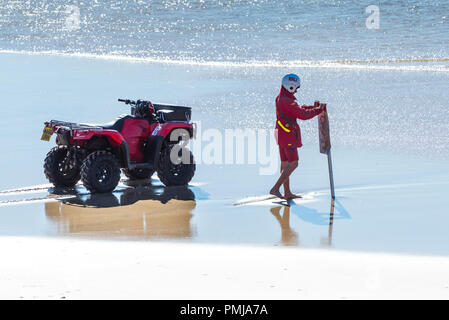 Un bagnino RNLI collocando un non nuotare un cartello di segnalazione sull Fistral Beach in Newquay Cornwall. Foto Stock