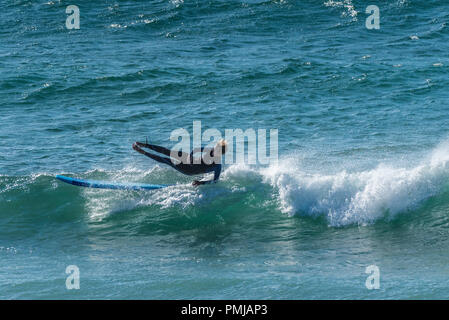 Un surfista cadere la sua tavola da surf a Fistral a Newquay in Cornovaglia. Foto Stock
