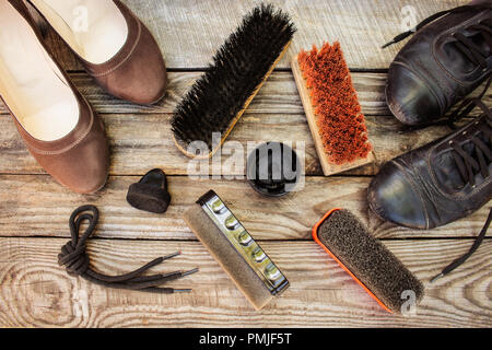 Scarpe donna e prodotti per la cura per calzature su sfondo di legno. Foto Stock