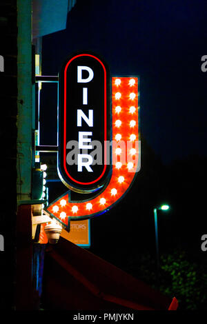 Un neon diner segno con una freccia di direzione rossa di notte (Big Moe's Diner, Aldgate, Londra, Regno Unito) Foto Stock