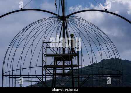 Workman in piedi sul ponteggio all'interno della struttura di acciaio, Ischia Porto, Napoli, Italia, Europa Foto Stock