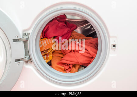 In prossimità di una macchina di lavaggio caricata con vestiti di rosso. Foto Stock