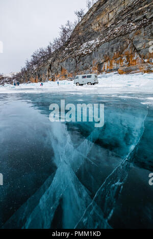 Persone in piedi dal bordo di un lago ghiacciato, Siberia, Russia Foto Stock