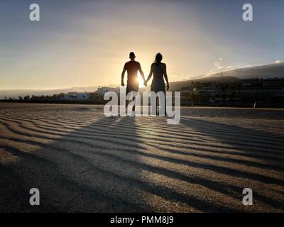 La silhouette di un uomo e di una donna Holding Hands, Playa de Morro Jable Fuerteventura Isole Canarie, Spagna Foto Stock