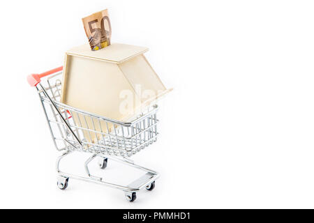 Acquisto di un nuovo concetto di casa. Casa a forma di scatola di denaro in un carrello della spesa Foto Stock