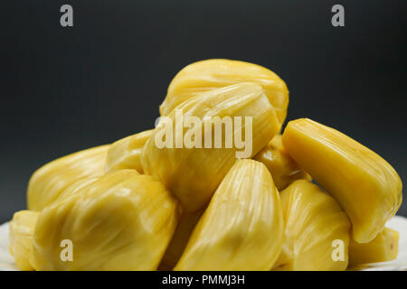 Jackfruit freschi fette su una piastra bianca. dolce jackfruit Giallo maturo. vegetariano vegano cibo crudo. Esotica frutta tropicali - closeup isolato Foto Stock