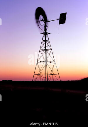 Il mulino a vento di acqua al crepuscolo in outback australiano Foto Stock