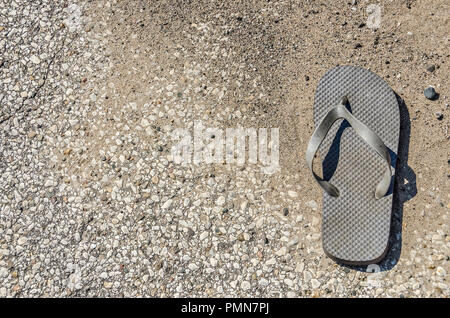 Qualcuno a sinistra o perso la loro flip flop in strada Foto Stock