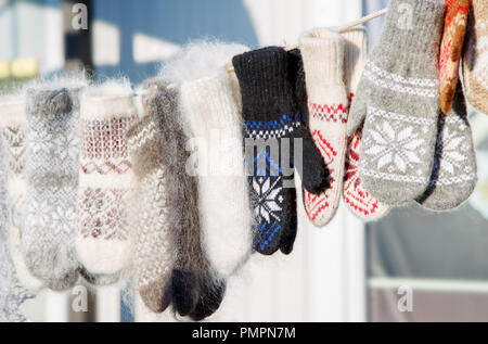 Guanti in inverno Mercatino di Natale. Una varietà colorato lavorate a maglia di lana guanti appeso a una fune. Regalo di Natale o di souvenir. Foto Stock