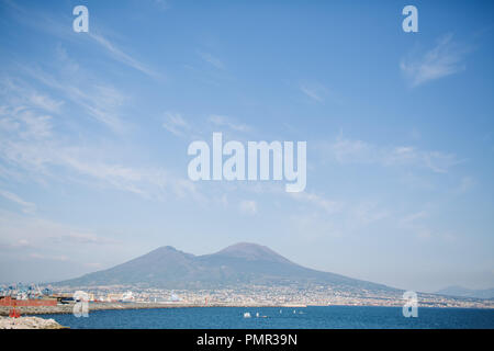 Una vista del Monte Vesuvio un vulcano vicino a Napoli, dalla riva di Napoli con il mare in primo piano su un giorno d'estate Foto Stock