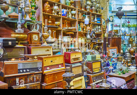 KASHAN, IRAN - 22 ottobre 2017: i mucchi di pezzi vintage - Radio, vasellame, statuette, samovars, caffè vasi e lampade a cherosene in negozio di antiquariato Foto Stock