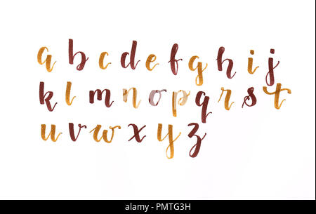 Scritte a mano, moderna calligrafia alfabeto in colori autunnali (marrone e oro) su un foglio di carta bianca, scritta a mano Foto Stock