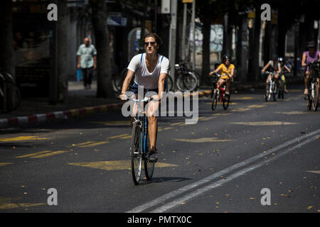 Tel Aviv, Israele. Xix Sep, 2018. 19 settembre 2018, Israele, Tel Aviv: una donna corse la sua bicicletta su una strada vuota durante la festa ebraica di Yom Kippur in Tel Aviv, Israele, 19 settembre 2018. Yom Kippur, noto anche come il giorno dell'Espiazione, è il santissimo giorno sul calendario Ebraico, sul quale il popolo ebraico eseguire il digiuno e intensa preghiera. Credito: Ilia Yefimovich/dpa/Alamy Live News Foto Stock