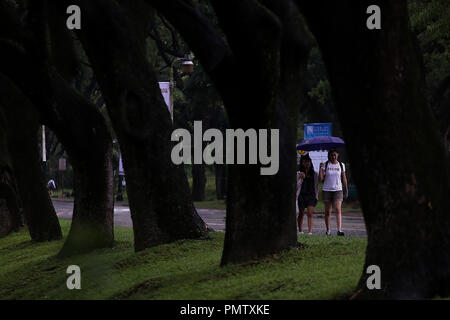 Quezon City, Filippine. Xix Sep, 2018. Le persone condividono un ombrello come si cammina attraverso la pioggia a Quezon City, Filippine, Sett. 19, 2018. Credito: Rouelle Umali/Xinhua/Alamy Live News Foto Stock