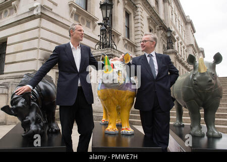 Ambiente segretario Michael Gove (destra) e Zac Goldsmith con il brosmio fiducia rhino statue d'arte al di fuori del Foreign Office di Londra, precedendo il traffico illegale di fauna selvatica Trade Conference. Foto Stock