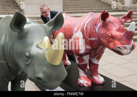 Ambiente segretario Michael Gove con il brosmio fiducia rhino statue d'arte al di fuori del Foreign Office di Londra, precedendo il traffico illegale di fauna selvatica Trade Conference. Foto Stock