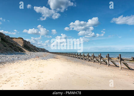 Pennelli in legno e revetments, fatiscente sulla West Runton Beach, North Norfolk. Foto Stock