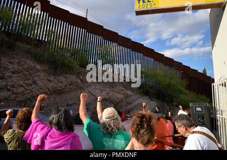 I manifestanti in Nogales, Sonora, Messico, sollevare i loro pugni al muro di confine a Nogales, in Arizona, Stati Uniti d'America, durante una manifestazione di protesta della ripresa di un adolescente in me Foto Stock